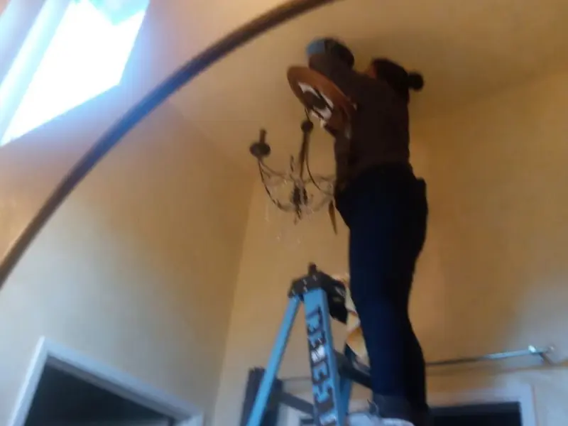 Electrician installing a chandelier in a Diamond Bar residence